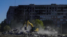 Bauarbeiter beseitigen mit Baggern die Trümmer eines zerstörten Gebäudes in Mariupol. Foto: epa/Stringer