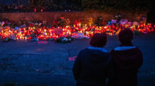 Zur blauen Stunde brennen zahlreiche Kerzen am Tatort eines Messerangriffs auf zwei Mädchen. Foto: Christoph Schmidt/dpa