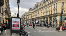 Auf einer Werbetafel informiert die Stadt Paris über eine Bürgerbefragung zu erhöhten Parkgebühren für SUV. Foto: Michael Evers/dpa
