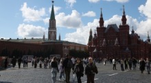 Passanten genießen einen Sommertag vor dem Kreml im Zentrum von Moskau. Foto: epa/Maxim Shipenkov