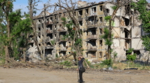 Ein Bewohner geht an einem beschädigten Gebäude in Mariupol vorbei. Foto: Victor/Xinhua/dpa