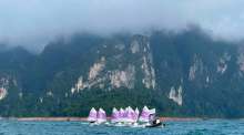 Teilnehmer der Segelregatta steuern ihre Optimist-Jollen vor der markanten Karstkulisse des Ratchaprapha-Stausees in Surat Thani. Bild: JS100 Radio