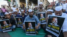 Indische Kongressanhänger halten Plakate während eines stillen Protests in Mumbai. Foto: epa/Divyakant Solanki
