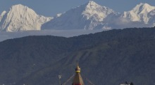 Das Ganesh-Himal-Gebirge erhebt sich bei klarem Wetter hinter einer Buddha-Stupa in Kathmandu. Die Szene zeigt den Alltag in Nepals Hauptstadt. Foto: epa/Narendra Shrestha