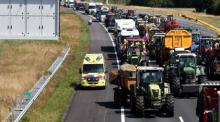 Ein Krankenwagen fährt auf der Autobahn A1 an Traktoren vorbei, während Landwirte in der Nähe von Oldenzaal gegen die Stickstoffpläne der Regierung protestieren. Foto: epa/Vincent Jannink
