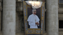 in Wandteppich, der den verstorbenen Papst Johannes Paul I. zeigt, wird bei der Messe zur Seligsprechung des Papstes an der Fassade des Petersdom enthüllt. Foto: Andrew Medichini