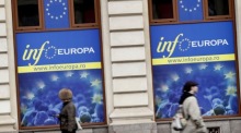 Menschen gehen an Plakaten mit EU-Aufschriften vorbei, die an den Fenstern des Informationszentrums des Europäischen Rates in der Bukarester Innenstadt angebracht sind. Foto: EPA-EFE/Robert Ghement