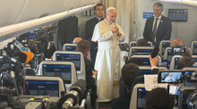 Papst Leo XIV. äußert sich während seiner Afrika-Reise im Flugzeug auf dem Weg nach Angola vor Journalisten. Foto: Christoph Sator/dpa
