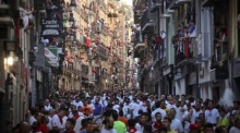Läufer und Stiere drängen durch die Estafeta-Straße beim siebten Stierlauf des San-Fermín-Festes in Pamplona. Foto: EPA/Villar Lopez
