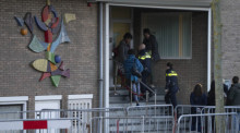 Zwei niederländische Polizeibeamte betreten das Hochsicherheitsgebäude des Gerichts in dem in Amsterdam der Prozess gegen eine berüchtigte Drogenbande stattfand. Foto: Peter Dejong/Ap/dpa