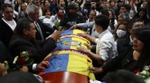 Mehrere Menschen umringen den Sarg des Kandidaten Fernando Villavicencio auf einem Messegelände in Quito, wo er zu einer öffentlichen Totenwache gebracht wurde. Foto: epa/Jose Jacome