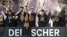 BBL-Pokal, Syntainics MBC Weißenfels - Bamberg Baskets, Final Four, Finale, Stadthalle Weißenfels. Weißenfels' Charles Callison (vorne) hebt nach dem Sieg den Pokal hoch während seine Teamkollegen feiern. Foto: Sebastian Kahnert/dpa