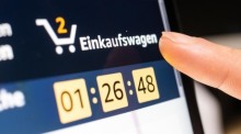 Eine Person klickt beim Online-Shoppen auf den Einkaufswagen. Foto: Mohssen Assanimoghaddam/dpa
