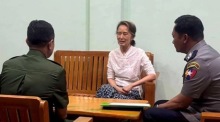 Aung San Suu Kyi sitzt mit Militär- und Polizeivertretern an einem unbekannten Ort. Ihre Haftstrafe wurde in Hausarrest umgewandelt. Foto: EPA/Myanmar Military Information Team
