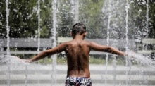 Ein Junge kühlt sich in einem Wasserbrunnen im Stavros Niarchos Kulturzentrum in Athen ab. Foto: epa/Kostas Tsironis