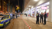 Polizisten stehen vor einem Supermarkt im Stadtteil Altona. Nach einem Streit zwischen zwei Menschen in einem Supermarkt ist eine Person mit mehreren Schnitt- und Stichverletzungen in ein Krankenhaus gebracht worden. Foto: Bodo Marks/dpa