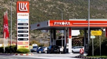 Autos stehen an einer Lukoil-Tankstelle nahe Skopje. Der russische Ölkonzern will wegen US-Sanktionen seine Auslandsbeteiligungen verkaufen. Foto: epa/Georgi Licovski