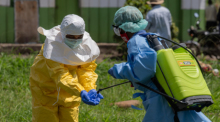 Ein Mitarbeiter des Roten Kreuzes wird nach einem Einsatz im Ebola-Gebiet in Rwampara desinfiziert. Foto: AP/Moses Sawasawa