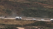 Ein israelisches Militärfahrzeug passiert nahe der Grenze zu Israel einen Konvoi der UN-Friedenstruppe UNIFIL im Südlibanon. Foto: epa/Atef Safadi