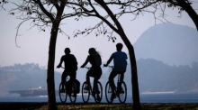Leute fahren mit dem Fahrrad durch Botafogo, mit dem Zuckerhut im Hintergrund, in Rio de Janeiro. Archivfoto: epa/ANDRE COELHO