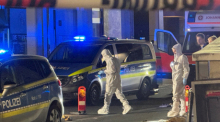 Mitarbeiter der Spurensicherung sind am Tatort in Kelkheim beschäftigt. Auf offener Straße hat ein Mann mit einer Schnittwaffe im hessischen Kelkheim seine Ehefrau getötet. Foto: Mike Seeboth/dpa