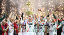 SC Magdeburg-Spieler Michael Damgaard jubelt nach dem Champions-League-Sieg mit der Trophäe in Köln. Foto: Marius Becker/dpa