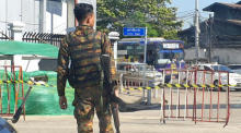 Eine bewaffnete Militärsoldatin überquert eine Straße in Yangon. Foto: epa/Stringer