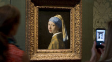 Besucher fotografieren das Gemälde «Das Mädchen mit dem Perlenohrgehänge» (1665-1667) des niederländischen Malers Johannes Vermeers während einer Vorbesichtigung für die Presse des renovierten Mauritshuis. Foto: Peter Dejong/Ap/dpa