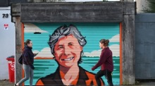 Passanten gehen in Dublin an einem Graffiti-Porträt der Präsidentschaftskandidatin Catherine Connolly vorbei. Foto: epa/Bryan Meade