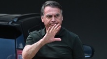 Brasiliens Ex-Präsident Jair Bolsonaro winkt bei seiner Ankunft an seinem Haus in Brasília. Nach einer Operation kehrte er in den Hausarrest zurück. Foto: EPA/Andre Borges