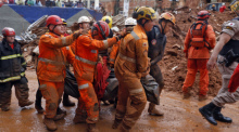 Feuerwehrleute und Helfer arbeiten nach schweren Überschwemmungen in Juiz de Fora zwischen zerstörten Häusern. Der Starkregen trifft auch Brasiliens Kaffeeanbau. Foto: Tânia Rêgo/Agencia Brazil/dpa