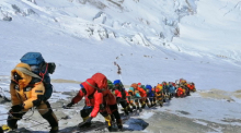 In einer langen Schlange klettern Bergsteiger auf einem Pfad knapp unterhalb von Lager vier am Mount Everest. Foto: Rizza Alee/Ap/dpa