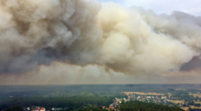 Eine große Rauchwolke steigt wegen eines Waldbrandes auf (Aufnahme mit Drohne). Das Feuer sei außer Kontrolle, womöglich drohe eine Evakuierung von Beelitz, sagte der Bürgermeister. Foto: Christian Guttmann/Brandenburg News 24/dpa