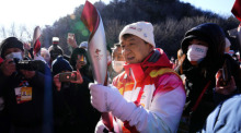 Schauspieler Jackie Chan hält die olympische Fackel für die Winterspiele 2022 in der Hand, nachdem er am Fackellauf an der Großen Mauer von Badaling am Stadtrand von Peking teilgenommen hat. Foto: Ng Han Guan/Ap/dpa