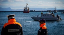Polizisten der Guardia Costiera beobachten das Rettungsschiff Sea-Eye 4 (C) in Italien. Foto: epa/Cesare Abbate
