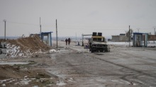 Zerstörte Fahrzeuge am Straßenrand, während Einheiten der syrischen Armee nahe der Frontlinie zu den SDF-Stellungen Stellung beziehen. Foto: epa/Ahmad Fallaha