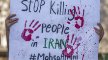 ine Demonstrantin hält ein Plakat auf dem rote Hände abgebildet sind, neben den Worten: "STOP Killing People in Iran #Masha Amini". Foto: Paco Freire/Sopa Images Via Zuma Press Wire