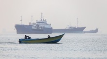 Iranische Fischer steuern ein Boot an wartenden Schiffen in der Straße von Hormus vor Bandar Abbas vorbei. Foto: epa/Amirhossein Khorgooei