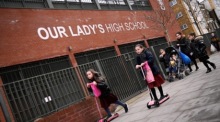 Kinder gehen an einer High School in London vorbei. Foto: epa/Andy Rain