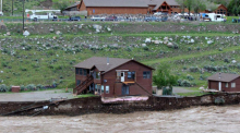 Auf diesem von Sam Glotzbach zur Verfügung gestellten Bild unterspült der überflutete Yellowstone River das Ufer und gefährdet ein Haus und eine Garage. Foto: Sam Glotzbach