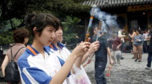Eine Gruppe von Studenten betet und verbrennt Weihrauch in einem Tempel in Shanghai. Foto: epa/Qilai Shen