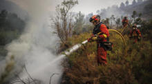 Feuerwehrleute bei der Arbeit, während ein Flächenbrand das Dorf Bejis in Castellon bedroht. Foto: epa/Biel Alino