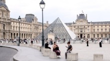 Besucher genießen einen Sommertag rund um das Louvre-Museum in Paris. Foto: EPA/Teresa Suarez