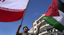 Während er die iranische Fahne bei der jährlichen Kundgebung zum Al-Quds-Tag oder Jerusalem-Tag zur Unterstützung der Palästinenser schwenkt. Foto: Vahid Salemi/Ap/dpa