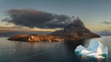 Eisberge und eine Siedlung im Abendlicht zeigen die raue Schönheit Grönlands, das geopolitisch von wachsendem Interesse ist. Foto: Unsplash/Mads Schmidt Rasmussen