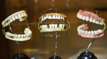 Im Dentalmuseum sind in der Sonderausstellung "Zerissenheit" sind in einer Vitrine Zahnprothesen für Menschen zu sehen, die keine eigenen Zähne mehr haben und das jeweils obere und untere Stück über Federn gehalte... Foto: Waltraud Grubitzsch/dpa