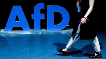 Ein Delegierter geht an einem Logo der Alternative für Deutschland (AfD) vorbei. Foto: EPA-EFE/Filip Singer