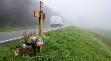 Ein Holzkreuz zum Gedenken wurde am Tatort an der K22 bei Kusel aufgestellt, wo Ende Januar 2022 zwei Polizisten im Dienst getötet wurden. Foto: Harald Tittel/dpa