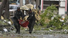 Polizisten transportieren nach einem Angriff einen Zylinder bei der Militärschule in Cali. Foto: epa/Ernesto Guzman