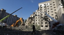 Ein ukrainischer Rettungskräfte-Mitarbeiter am zerstörten Wohnhaus nach einem russischen Raketenangriff auf Kiew. Foto: EPA/Sergey Dolzhenko